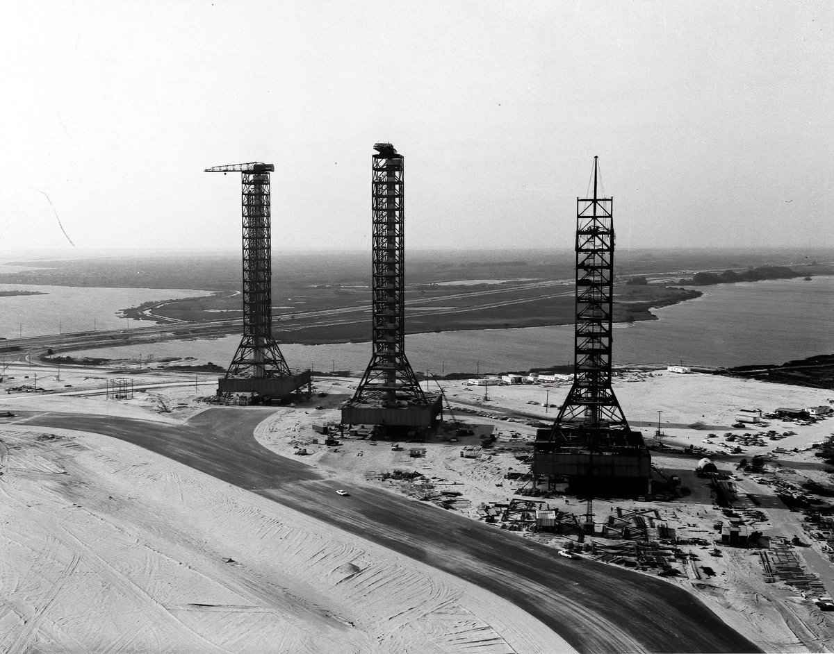 MLP 2 & 3 were finished in December 1964 and March 1965. 2nd image: "Hundreds of construction workers, community leaders, and NASA and contractor employees were present on April 14, 1965 for a ceremony marking off the "topping off" of the Vehicle Assembly Building."