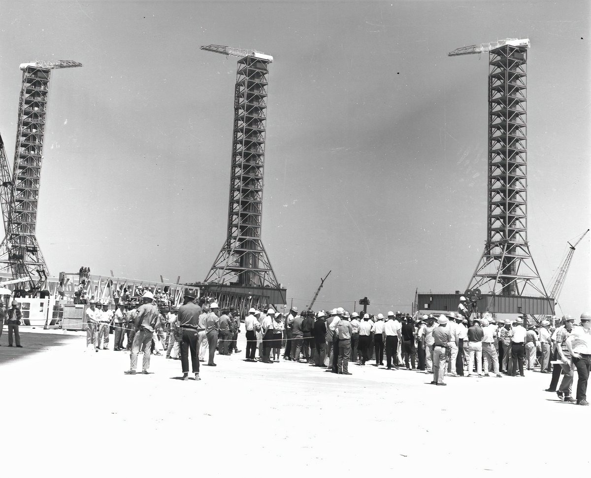 MLP 2 & 3 were finished in December 1964 and March 1965. 2nd image: "Hundreds of construction workers, community leaders, and NASA and contractor employees were present on April 14, 1965 for a ceremony marking off the "topping off" of the Vehicle Assembly Building."