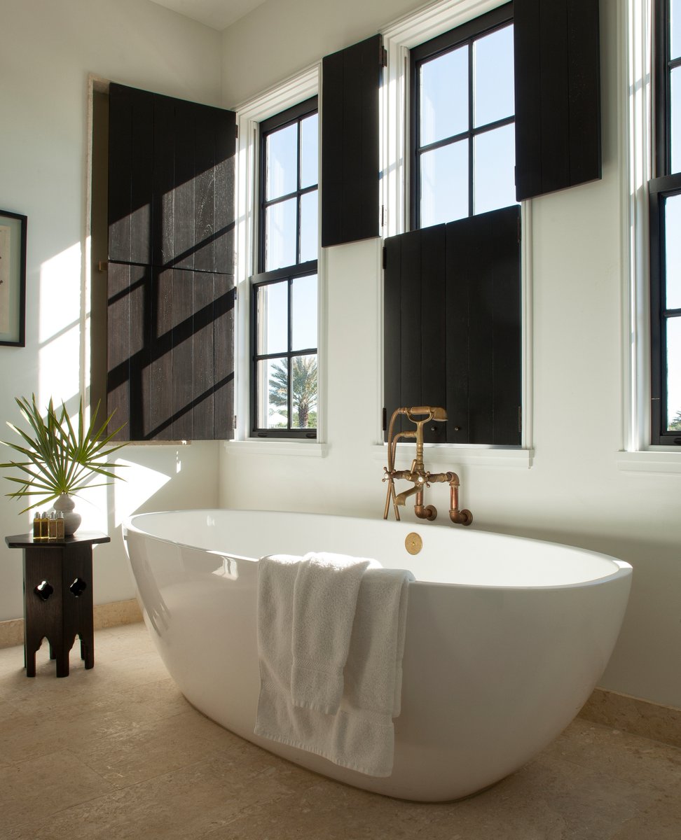 In this bathroom, the black wooden shutters and furnishings help to achieve depth whilst also softening the stark contrast whiteness of the Barcelona tub. Credit: Khouryvogt on Instagram & Jack Gardner Photography l8r.it/fm2T #baths #bath #VictoriaandAlbertBaths