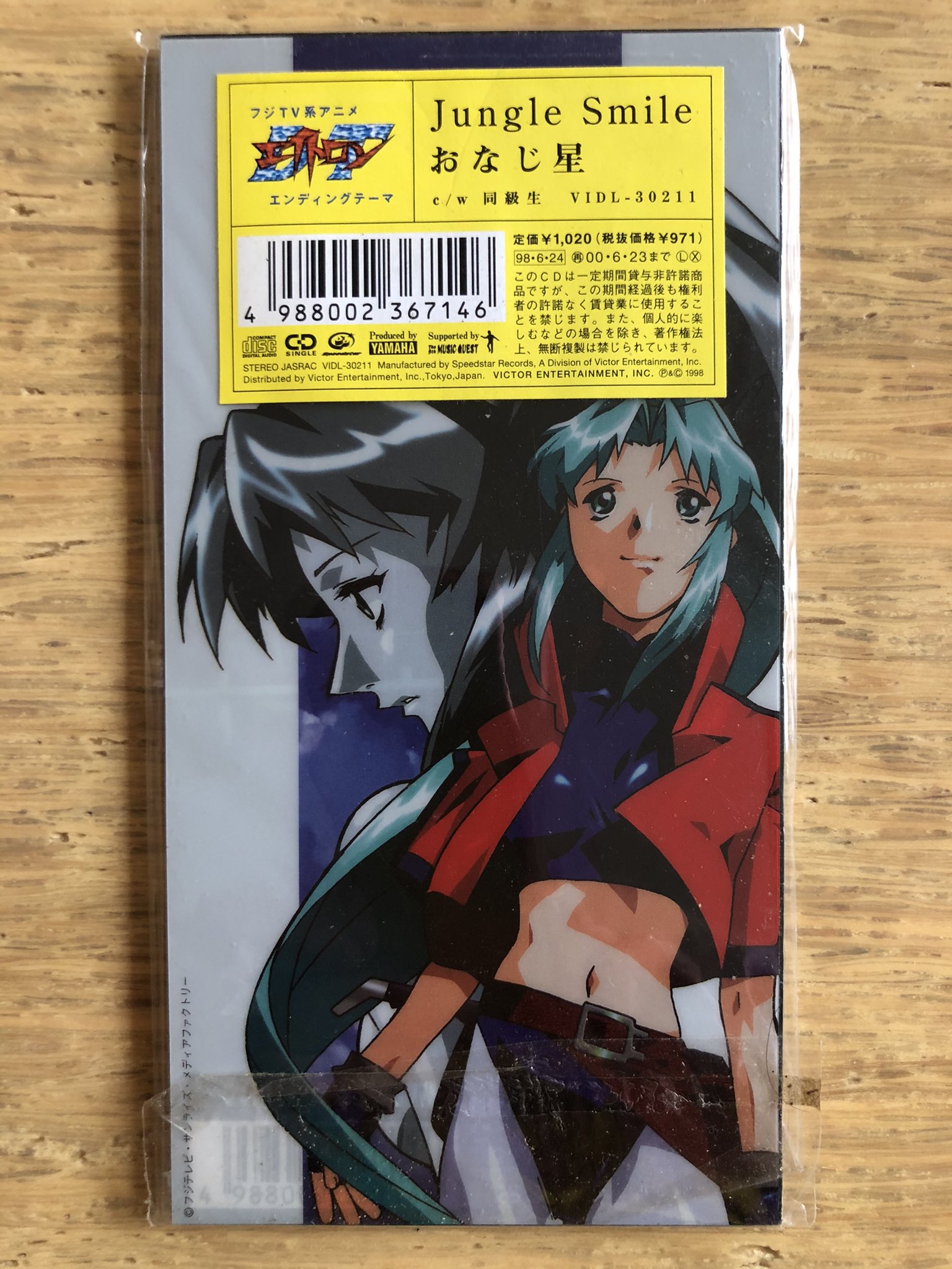 Nakamura8cm シール付き8cmcd おなじ星 Jungle Smile 1998年6月24日発売 作詞 高木郁乃 作編曲 吉田ゐさお 表シールは黒いジャケに重ねると字が読める 歌詞の一部をシールに記載 裏は別刷プラスチック製アニメジャケが本来の裏ジャケのバーコードや価格