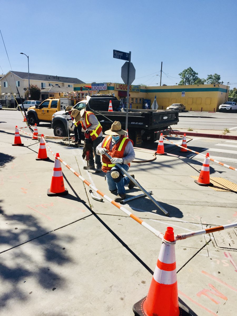 Bureau of Street Lighting workers install street lights, while wearing face masks.