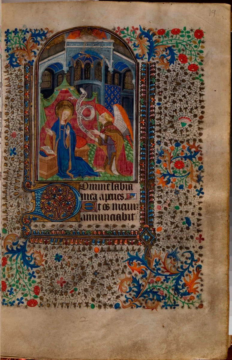 Folio 19v depicts the Annunciation of the Blessed Virgin Mary. Mary is at prayer in a covered chapel while the angel greets her. The Holy Spirit descends from above, from the head of God the Father – this image is smudged.  #BookofHours