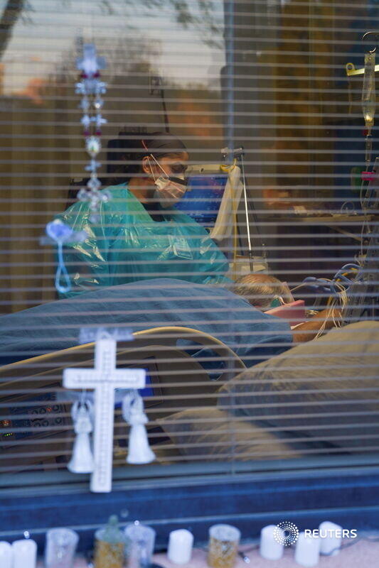 Viewed through a medical center window in New Mexico, nurse Carolina Garcia took care of her father Jose Garcia.Photos by  @PaulRatje Full story:  https://www.reuters.com/news/picture/new-mexico-hospital-nurse-cares-for-her-idUSRTX8D0BF