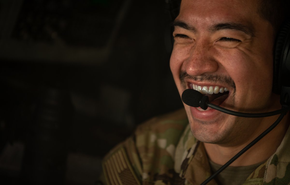 A U.S. Air Force KC-135 Stratotanker in-flight refueling specialist, assigned to the 340th Expeditionary Aircraft Refueling Squadron, enjoys a conversation with other crew members during an air refueling mission over Southwest Asia, Dec. 22, 2020. The KC-135 Stratotanker delivers U.S. Air Forces Central a global aerial refueling capability to support joint and coalition aircraft throughout the U.S. Central Command area of responsibility. (U.S. Air Force photo by Staff Sgt. Trevor T. McBride)