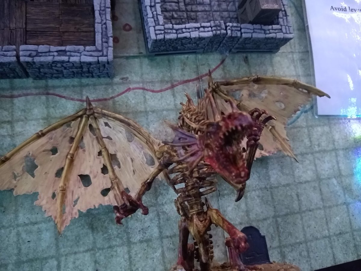 Cyborgdude_'s tweet photo. Behold as the deadly dracolich descends upon the local inn. Decorated with all my miniature birthday gifts. Skulls, rocks, and tombstones!🖌️#tabletop #DnD #dragons #skeletons #roleplaying @wizkidsgames https://t.co/6JPSZUhY98