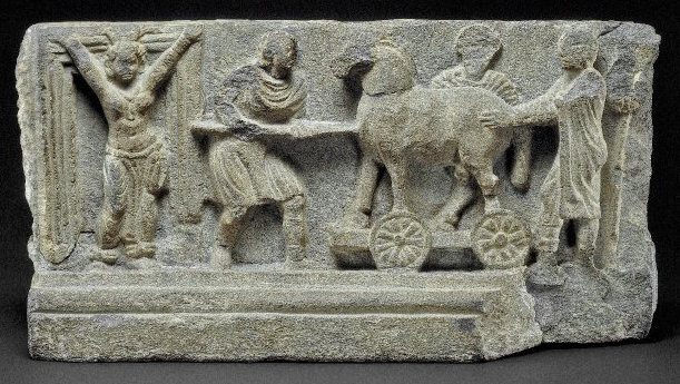5/89The British Museum in London houses a metamorphic tablet, possibly part of a stair-riser on a 2nd century Buddhist stupa in Gandhāra (today's Qandhar, Afghanistan). This piece depicts a horse being wheeled toward a doorway guarded by what appears to be a topless girl.