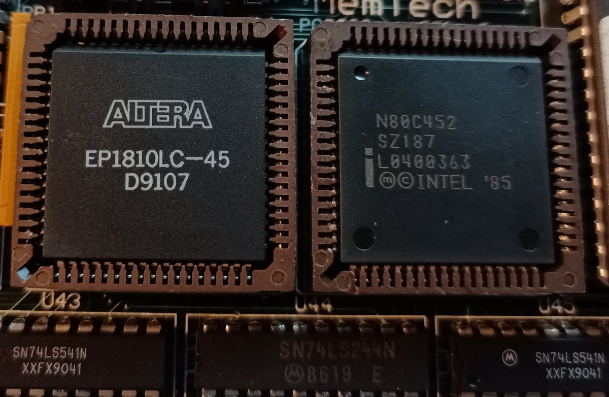 So it's got an Altera EP1810LC-45, that's a CPLD (which are kind of proto-FPGAs).The chip next to it is an Intel 80C452, which is an 8051 (TAKE A DRINK) designed for I/O use.