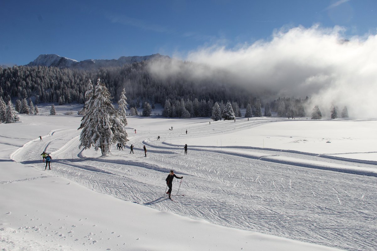 De nombreuses personnes sont présentes sur le domaine de ski de fond à Chamrousse 1600 pour profiter du soleil et de la neige fraîche.