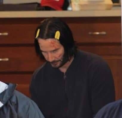 partygirlu2's tweet photo. today i offer you keanu reeves wearing yellow hair clips https://t.co/q17L0xzETc