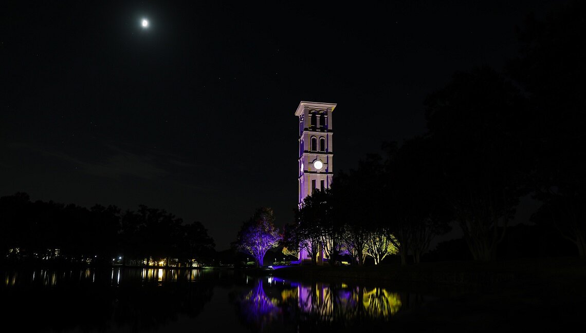 The Furman University Bell Tower in Greenville, SC lit up in purple and gold on August 26, 2020 for the #ForwardIntoLight celebration. #WomensVote100 #GreenvilleSC #SouthCarolina <a href="/FurmanU/">Furman University</a> womensvote100.org/forwardintolig…