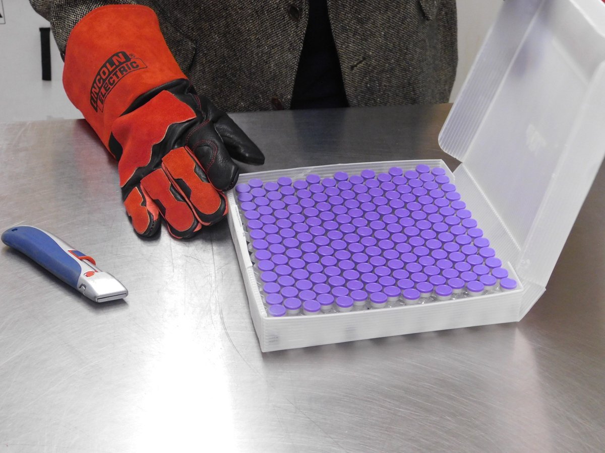 Small tubes containing the COVID-19 vaccine on a table.