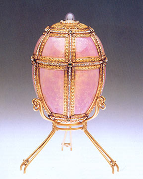 The exterior of this egg is pink-mauve enameled gold split into twelve sections. It measures 102 mm (4 in.) tall by 67 mm (2 5/8 in.) wide. Six vertical lines of rose-cut diamonds and three horizontal lines separate the enameled panels from one another.