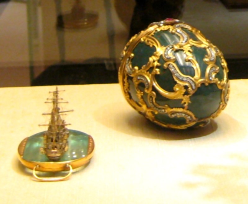 The surprise contained within is a miniature replica of the Imperial Russian Navy cruiser Pamiat Azova (Memory of Azov), executed in red and yellow gold and platinum with small diamonds for windows, set on a piece of aquamarine representing the water.