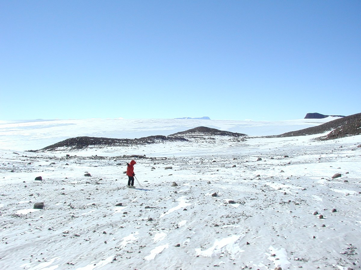 12-15-2000 A member of  #ANSMET2000 team walking across rock-strewn field. Very hard to find meteorites in such a place but there are some.