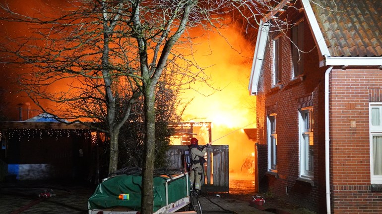 Brandende chalet in Ter Apel, Drentse brandweer helpt met blussen: Aan de Agostraat in Ter Apel is een chalet achter een woning afgebrand.