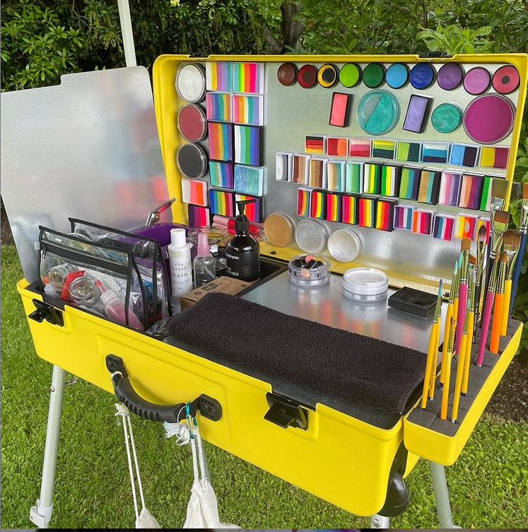 craftngo's tweet photo. Christmas painting in the park in New Zealand! @thebigyellowpaintbox (Love the name!) is giving us all hope! Beautiful setup! 
Location: Gore, Southland NZ
#facepaintsetup #newzealand #newzealandfacepainter #facepaintkit #christmasinthepark #craftngo  #facepainter #facepaint https://t.co/NHNO4h6GfK