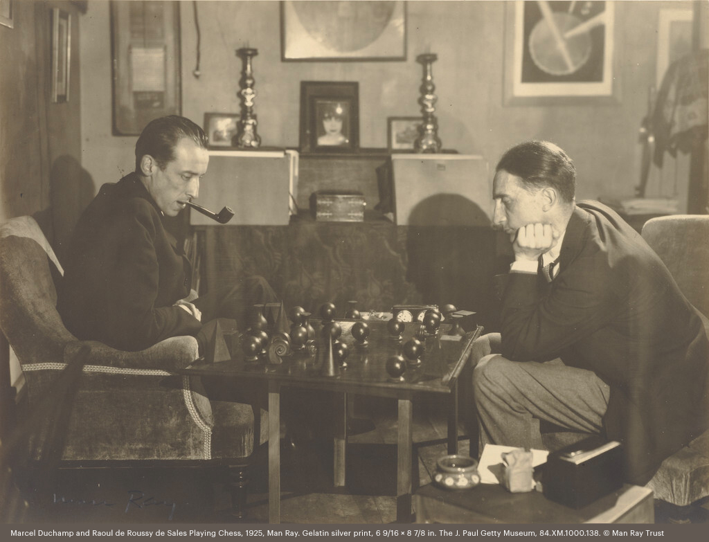 Duchamp grew up playing chess with his siblings, and he played in high-profile chess tournaments around the world.In this photograph, Duchamp is playing chess with French journalist Raoul de Roussy de Sales.