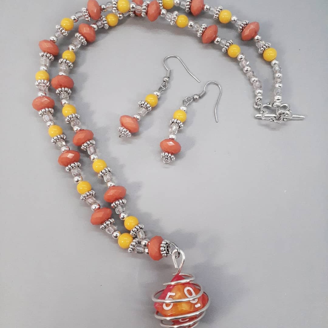 We just added this peach and yellow D10 dice necklace with matching earrings set to our #Etsy shop this evening. 

The colors remind us of chewy fruit candy. 🍒🍊🍍

Shop link in profile. 

#GamerGiftsByFSP #necklaceandearringset 
#dicenecklaces