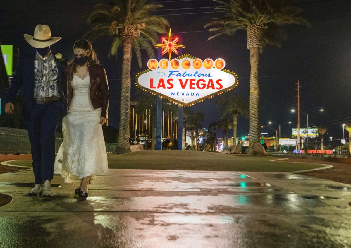 KistnerKarl's tweet photo. Newlyweds Jonathan Figueroa, 25, and Catherine Gibbs, 32, of Temperance Mich., walk in damp weather Thursday near the “Welcome to Fabulous Las Vegas” sign. @EliPagePhoto @reviewjournal The rain broke a record dry spell. See story by @alexisdford at https://t.co/ixVVtbMoHu https://t.co/Ptl7c5z6jH