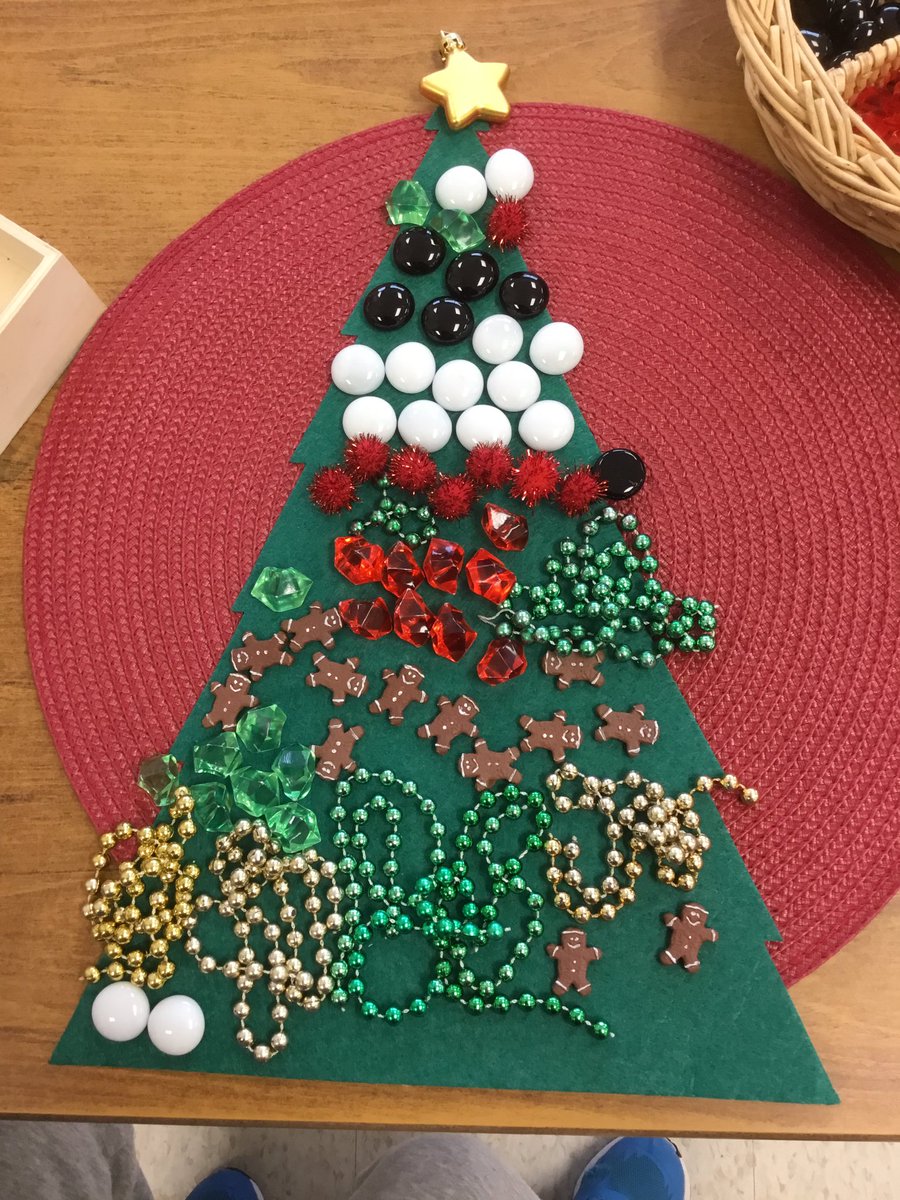D.P. used a variety of loose part materials to decorate felt Christmas tree cutout.  "My tree is so beautiful and it has a star on top." said D.P.