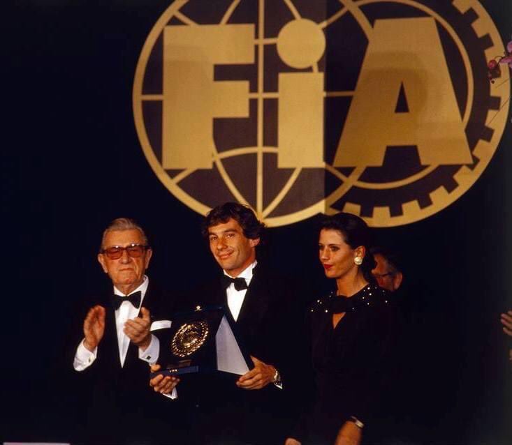F1Tornello's tweet photo. No puedo parar de reírme de la cara de frustración de Balestre. Cómo odiaba tener que entregarle el trofeo de campeón a #AyrtonSenna Fue en la gala de FIA de 1990 😂😂 Vía @1990sF1 https://t.co/Aubs2Ij5tm