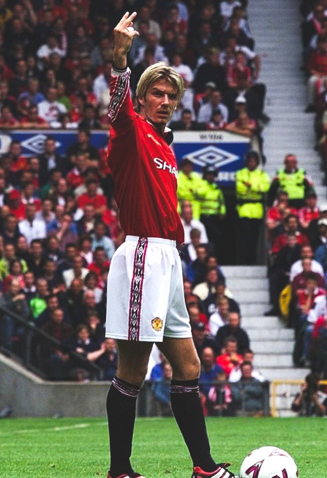 David Beckham lets the Leeds United fans know what he thinks of them as they sing songs about his Mrs and his Son during a game at Old Trafford, 1998.