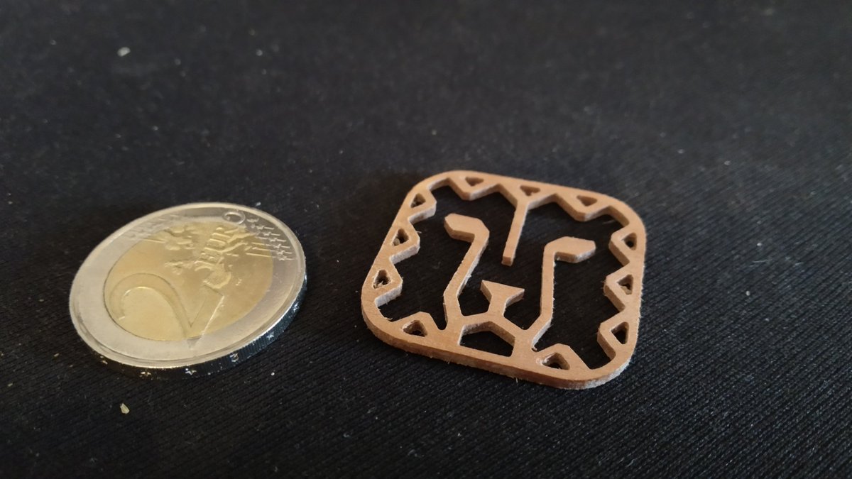 Essai de découpe de précision à la CNC. Placage merisier contre collé à 90°. Épaisseur 2mm. Diam 1/32", 6 passes à 0.3mm.