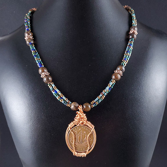 1944 British halfpenny with three strands of seed beads. $90.