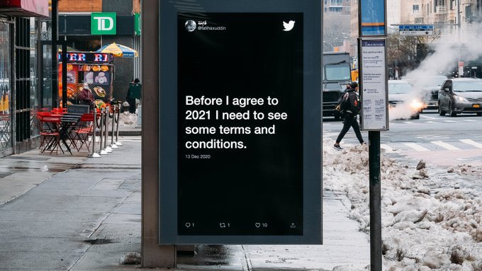 Tweet on a bus station in nyc that reads “before I agree to 2021 I need to see some terms and conditions.”