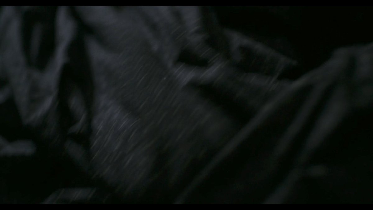 A death of a mother in  #Ammonite. The camera lingers upon the black folds of clothing drawn over the body.Suddenly, tenderness. A daughter squeezes the bare foot of her mother.It is the first time they've touched in the film. Death allows for a tenderness that life forbids.