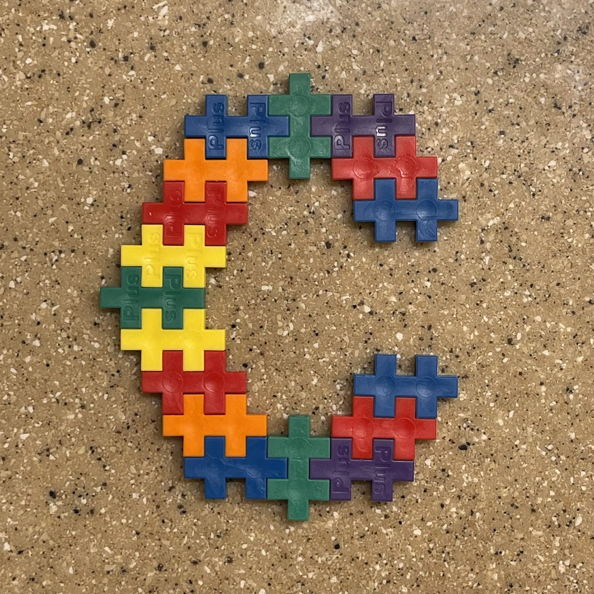 Several plus-plus toy pieces forming the shape of a C