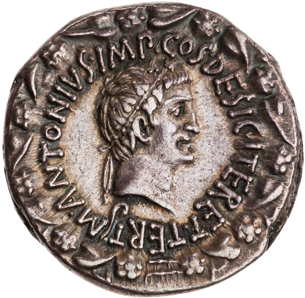 The Obverse is a portrait of Antony wearing a diadem, in the model of the Hellenistic rulers, inside a wreath of ivy leaves. The Legend, however, is markedly republican: M. ANTONIUS IMP. COS. DESIG. ITER. ET TERT. - 'Marcus Antonius Consul Designate for the second and third time'