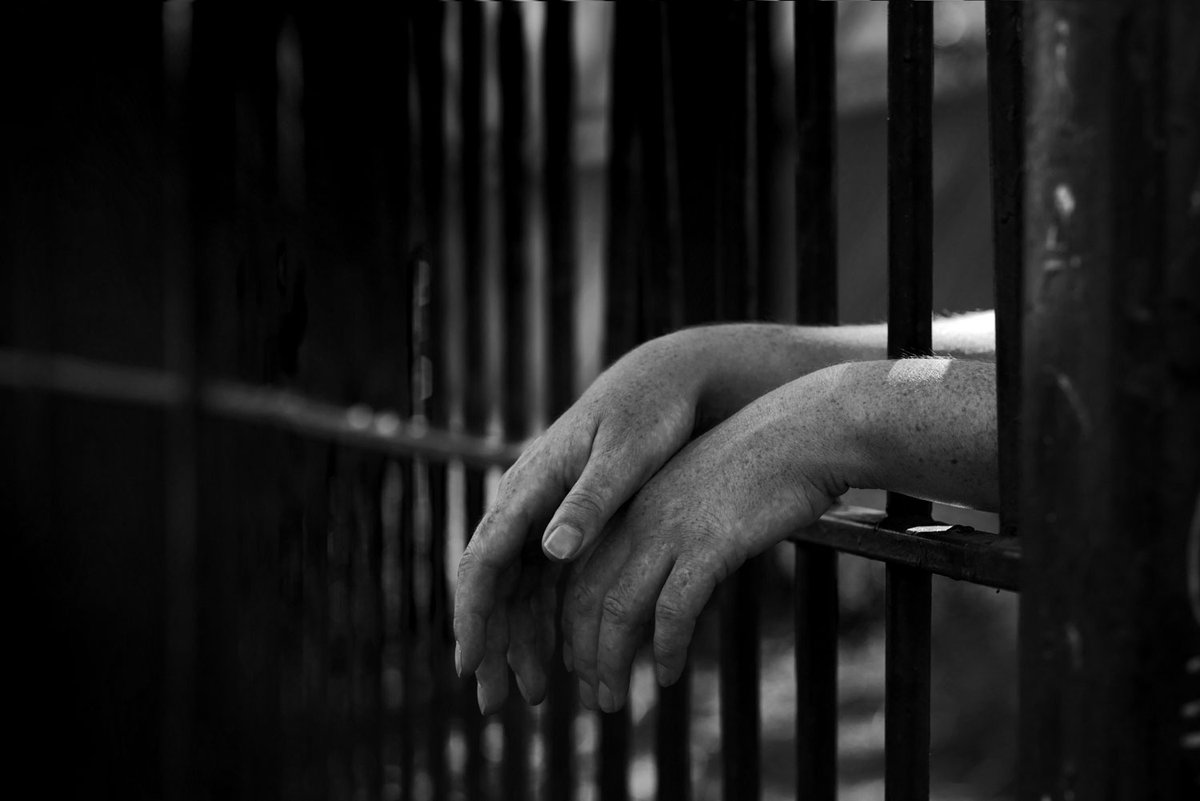 преступник за решеткой. страх толпы. тюремная клетка. мужчина в клетке. боюсь осужденных.