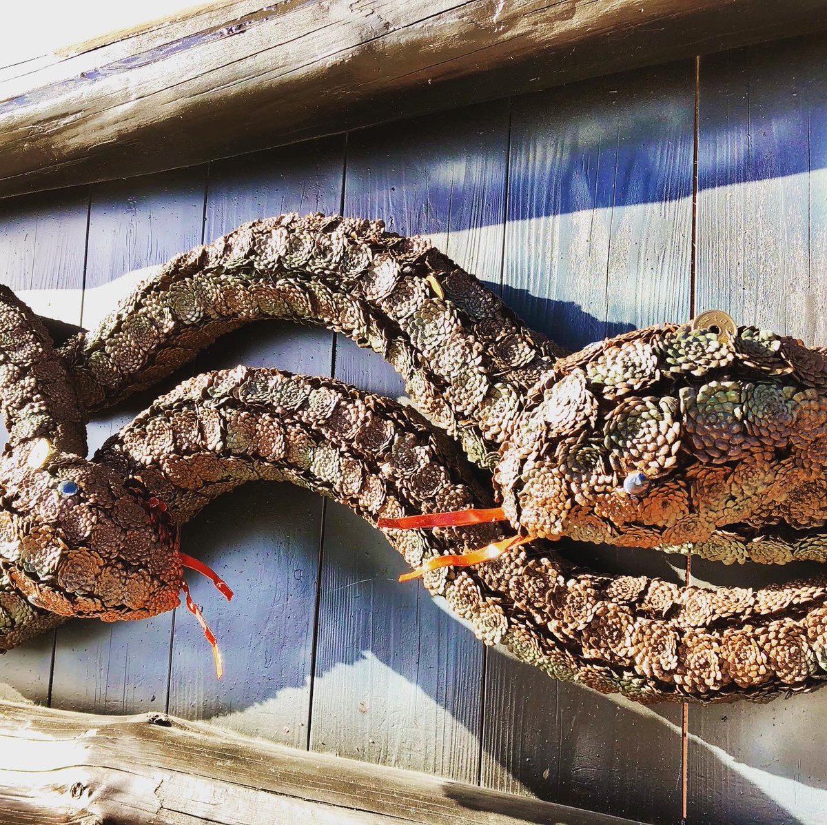 松ぼっくりで出来た蛇神様。これ以上の劣化を防ぐために塗装を施して