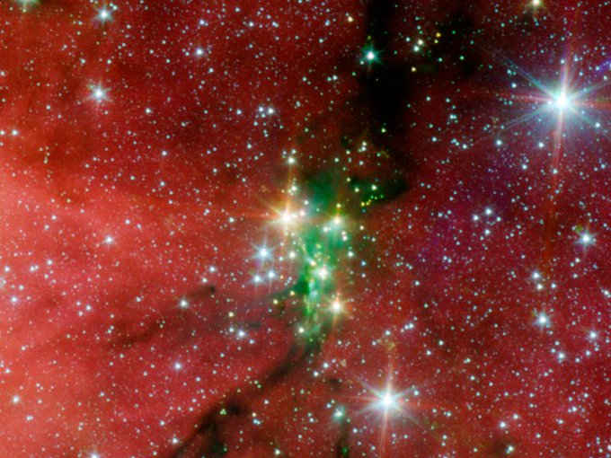 Decked out in holiday red and green, the Serpens South star cluster shines in this infrared photo from the Spitzer Space Telescope. It previews what #NASAWebb may see when it investigates star-forming regions. The cluster holds 50 young stars