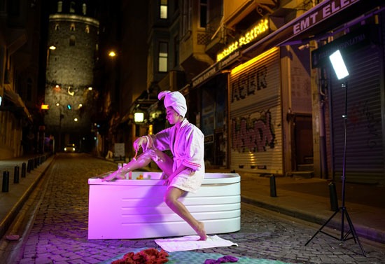 احتجاجا على سوء معاملة أردوغان للسيدات.. تصوير "فوتو سيشن" لفنانة تركية تستحم فى الشارع