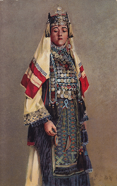 Ogledalo – a small mirror suspended from a chain or silk cord, worn hanging from the kanica; meant to thwart the evil eye. (Bride from Zmijanje. Notice how she averts her gaze and clutches at the mirror)Opanci – oputnjaši of rawhide made from tanned leather by craftsmen