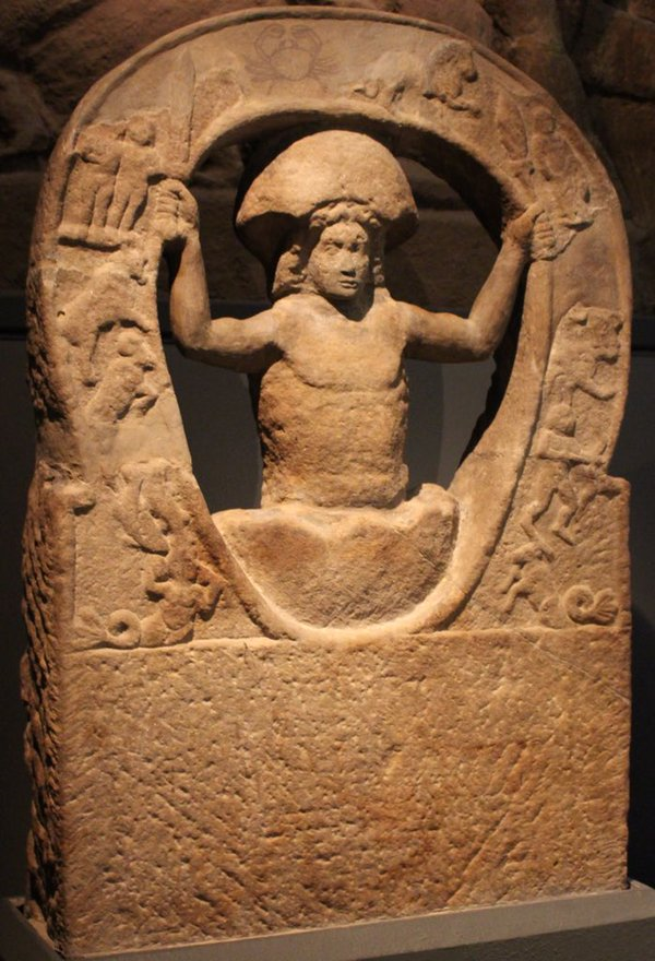 Mithra hatching from an egg or rock. Holding the Zodiac.