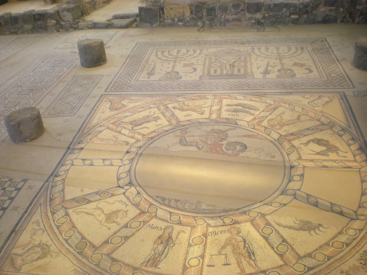 You can see there that Sol is in the middle of a zodiac wheel, a common motif in the Roman empire. And above, there are two menorahs and a Torah shrine. The zodiac signs are labeled in Hebrew, but Greek is also present.