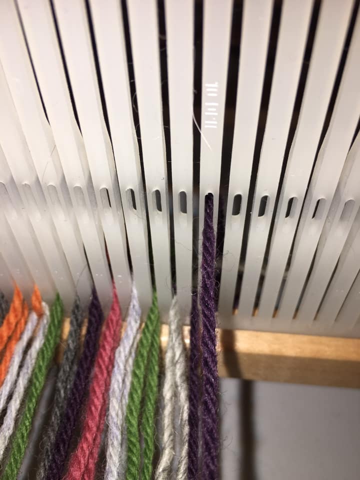20/ The reed has slots and holes. Yarn in each is what allows you to lift and lower the strands. So you need to put the yarn in the holes. There is a hook for this