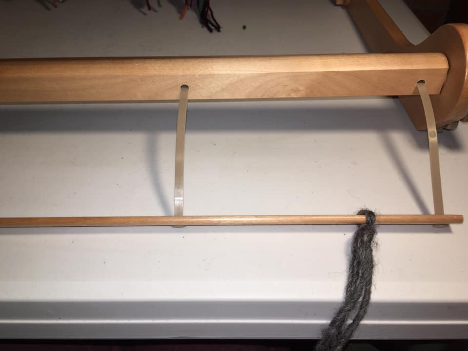 24/ Now you have to connect these knots to the front roller of the loom. So you thread a long piece of yarn through the top and bottom threads allowing the knot to old it on the inside.