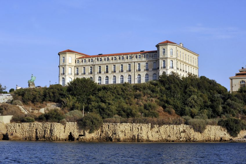 Marseille was France's colonial metropolis, where movements to and from the colonies were regulated.As we get nearer to the port, you will notice on the right on the shore the Palais du Pharo. This was, from 1905 to 1975, the School of Colonial Medicine.