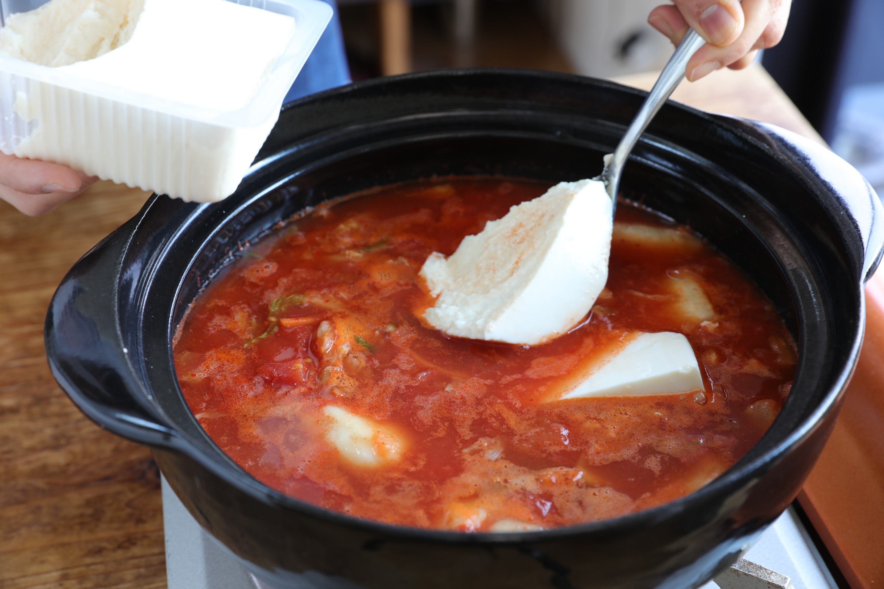 Twitter 上的 ぐっち夫婦 料理家 トマト缶入れると マイルドな味に トマト缶で作る 豚バラトマト純豆腐 鍋にトマト缶 水 鶏ガラスープの素 水 酒 しょうゆを入れ温め 白菜キムチ 豆腐 豚肉も 肉に火が通ったら弱火で卵 固まったらニラ 火を止めふた
