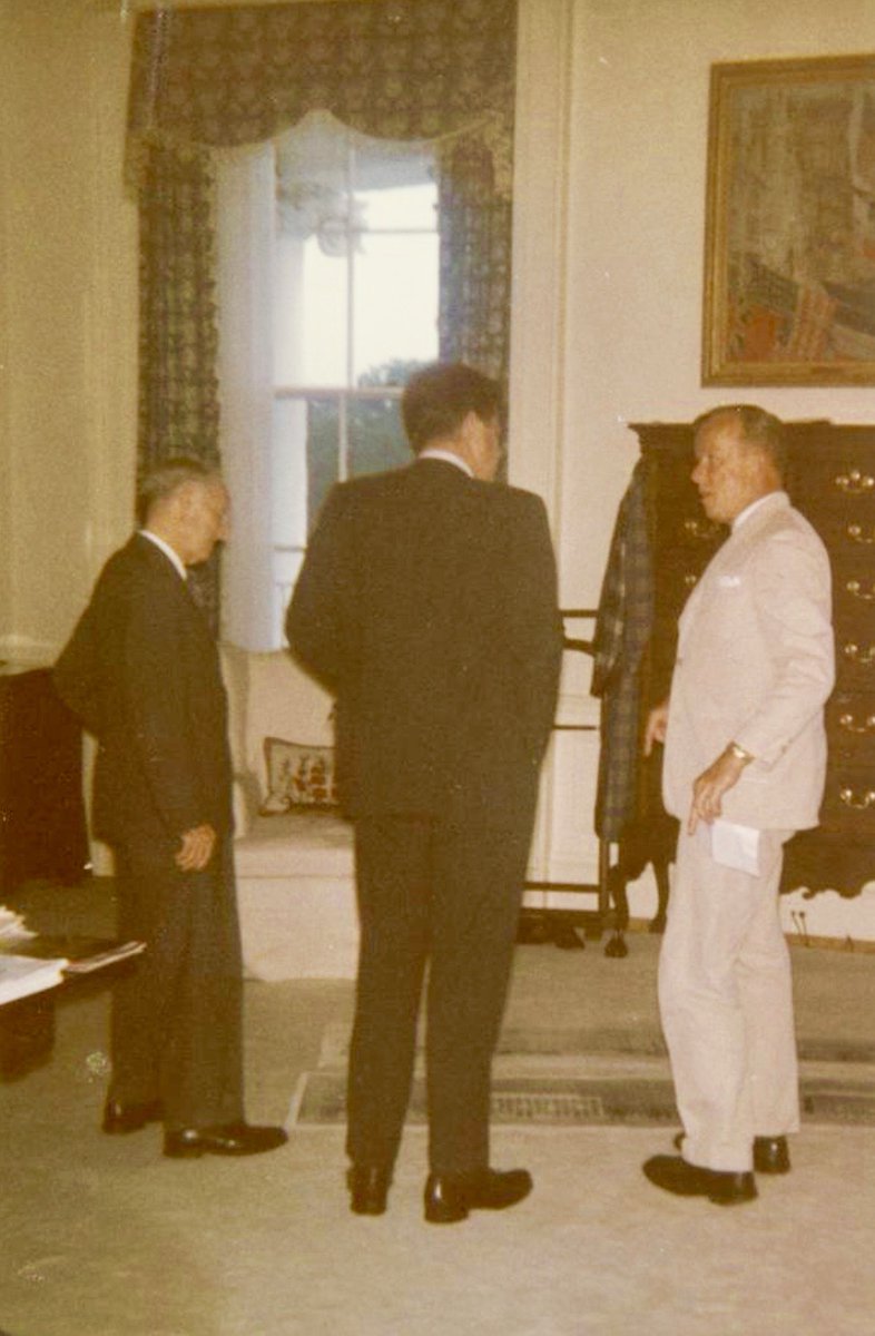 JFK in President’s bedroom discussing art and furnishings with David Finley, chair of White House Historical Association, and William Walton of Fine Arts Commission. Childe Hassam’s “Allies Day, May 1917” is on wall, above JFK’s dressing robe on hanger:         #JFKL
