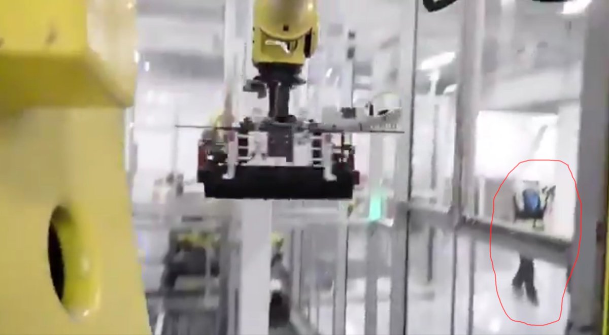 4/There's an interesting detail in one of the frames: glimpse of a facility worker observing an industrial robot moving a rack.