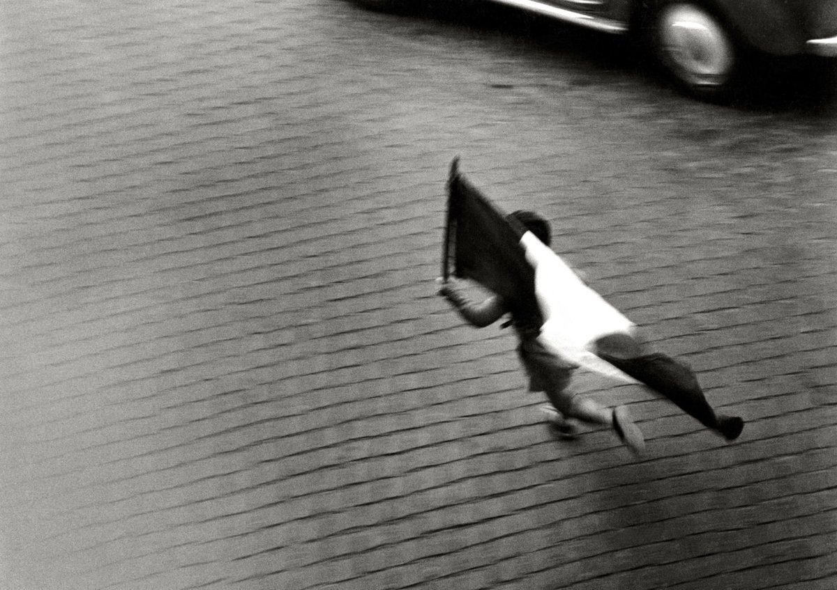 Herbert List - Little Garibaldi. A boy with an Italian flag running towards the Ponte Palatino. Rome, 1953.