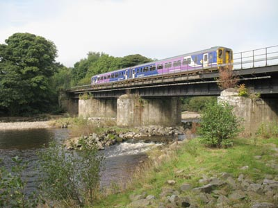 Trains distribute loads better but rail vehicles are much heavier than road vehicles. Trains exert bigger forces on bridges under braking which also needs to be taken into account. Tall bridges often have major wind loads to consider.