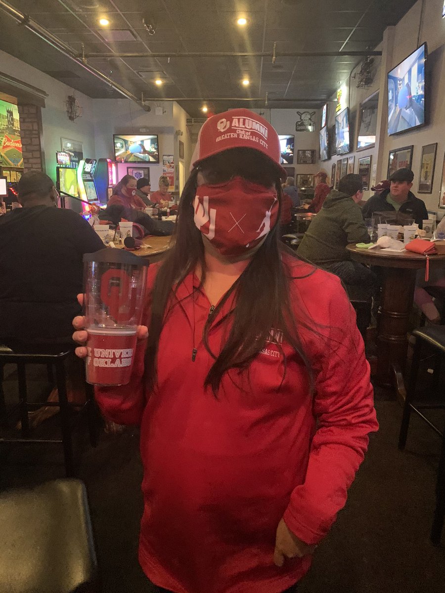 senoroukc's tweet photo. My wife with her 2 items she won. A new hat and a new cup at halftime. And with OU gymnast Russ Czechin. #BoomerSooner @OUClubKC @OU_Football @OU_Alumni #kcsooners https://t.co/Al7cCZXdJQ
