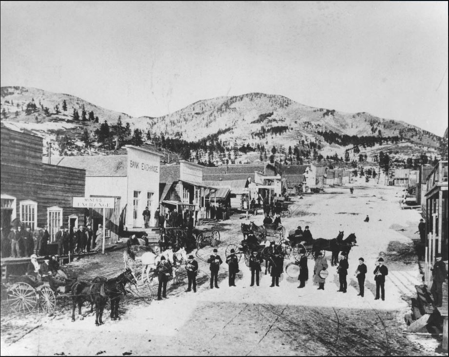 Maiden, Montana. The main street of the gold mining town of Maiden in the Judith Mountains, Montana. Many buildings line both sides of the street. The Maiden band is in a semi-circle in the street on New Year's Day. 1887. #mthistory #montana #history buff.ly/38dMt10