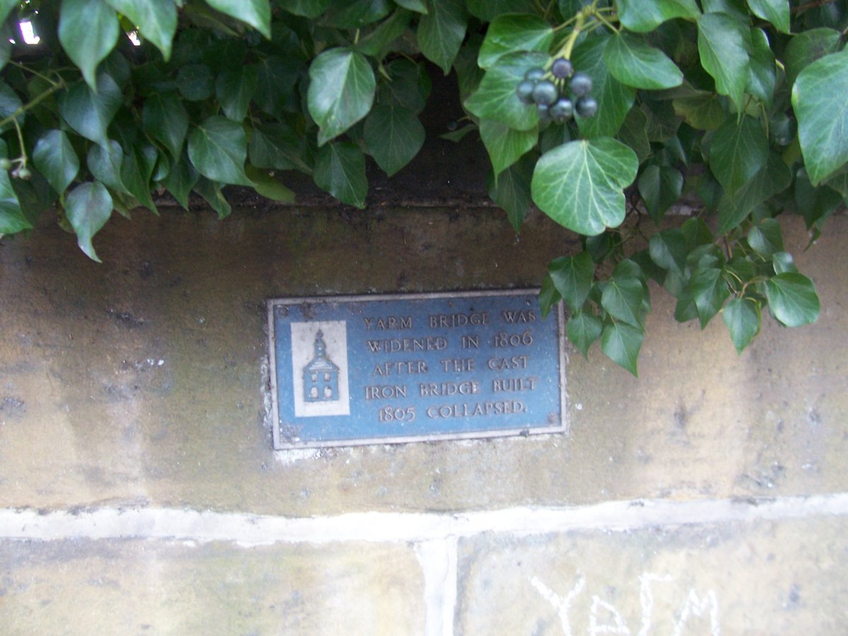 In 1805, the medieval stone bridge was considered old hat and an iron bridge was built to replace it. But it collapsed after three months of use and was never rebuilt. "A blue plaque telling the story? Go on then, but under the ivy. It's a bit embarrassing..."  #yarmmicrohistory